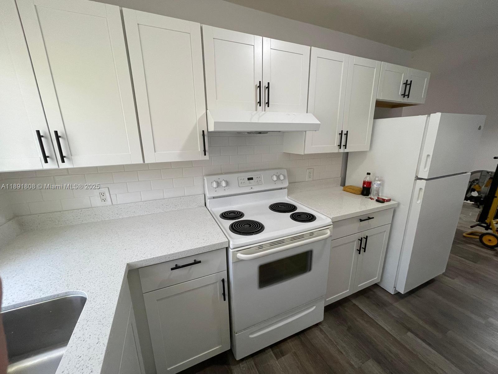 5040 Sanctuary Way, Unit B West Palm Beach, FL 33417 - Photo 2 of 10 a kitchen with white cabinets and white appliances