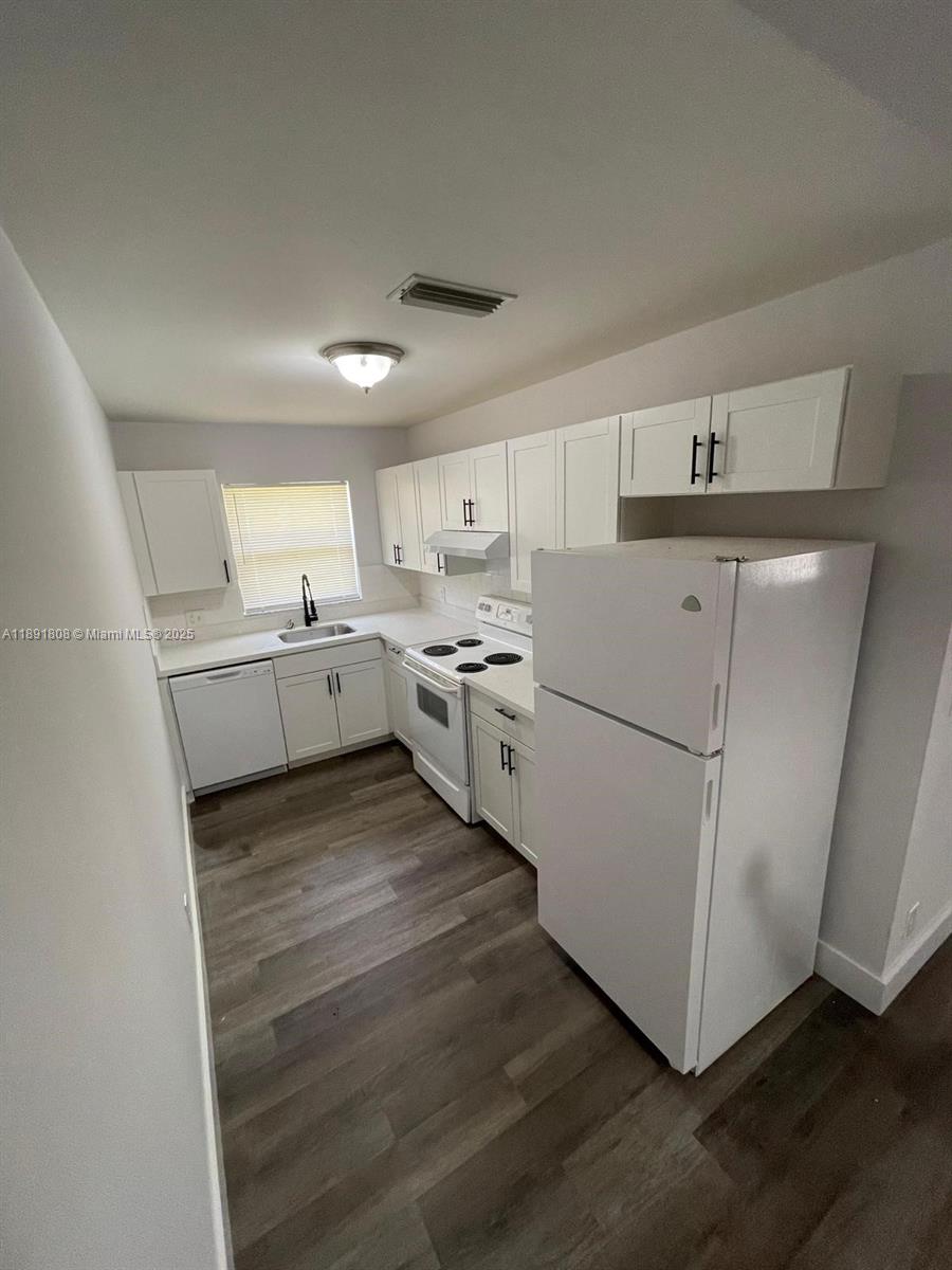 5040 Sanctuary Way, Unit B West Palm Beach, FL 33417 - Photo 3 of 10 a kitchen with white cabinets and white appliances