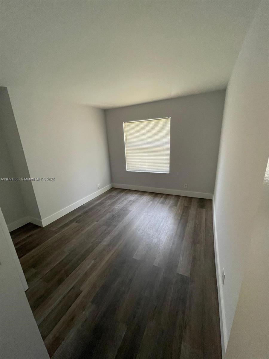 5040 Sanctuary Way, Unit B West Palm Beach, FL 33417 - Photo 9 of 10 an empty room with wooden floor and windows