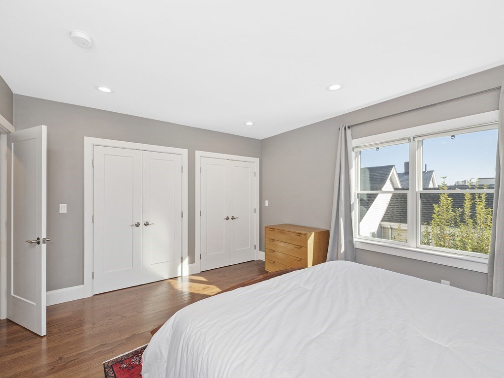 198 California Street, Unit 3 Newton, MA 02458 - Photo 19 of 34 a bedroom with a bed and wooden floor