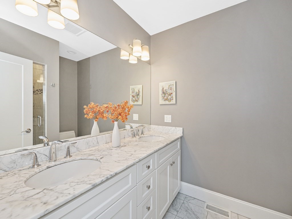 198 California Street, Unit 3 Newton, MA 02458 - Photo 25 of 34 a bathroom with a granite countertop double vanity and a mirror