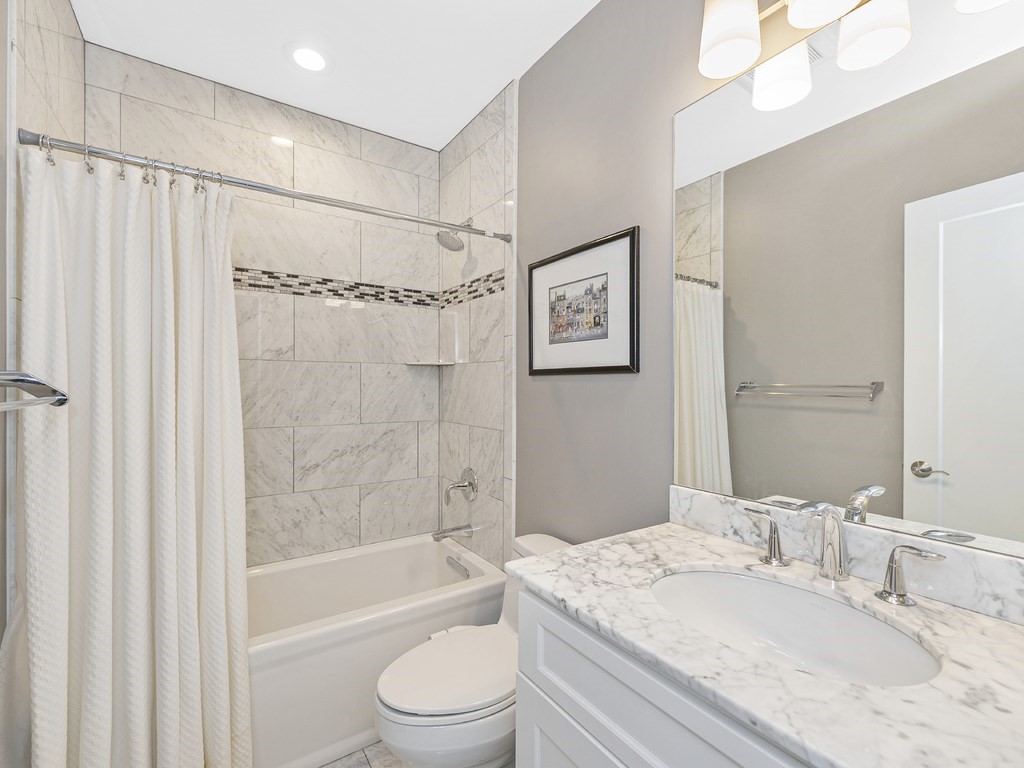 198 California Street, Unit 3 Newton, MA 02458 - Photo 27 of 34 a bathroom with a granite countertop sink a mirror a shower and a bathtub