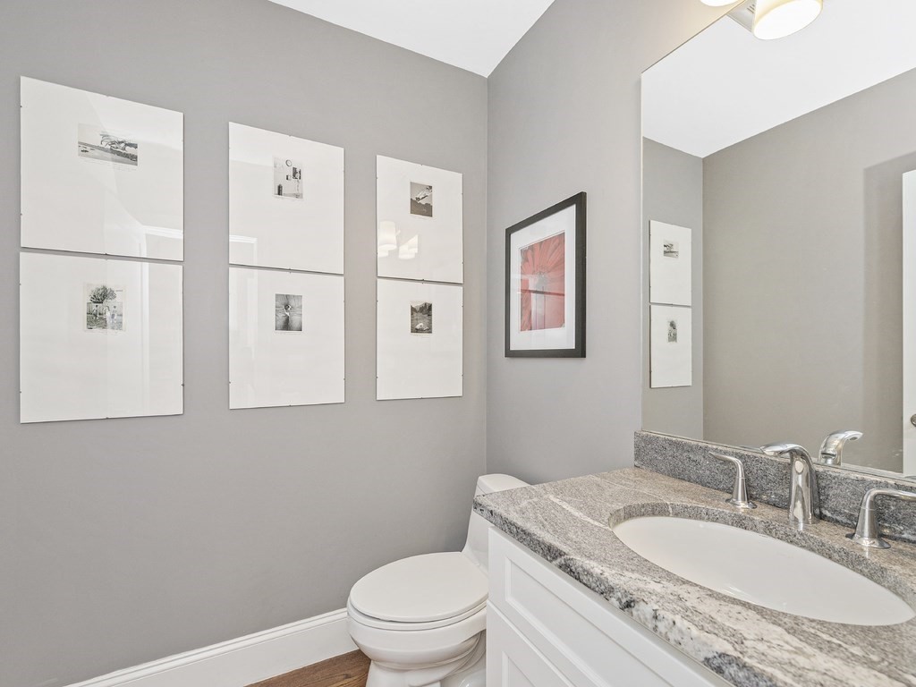 198 California Street, Unit 3 Newton, MA 02458 - Photo 28 of 34 a bathroom with a granite countertop toilet a sink and a mirror