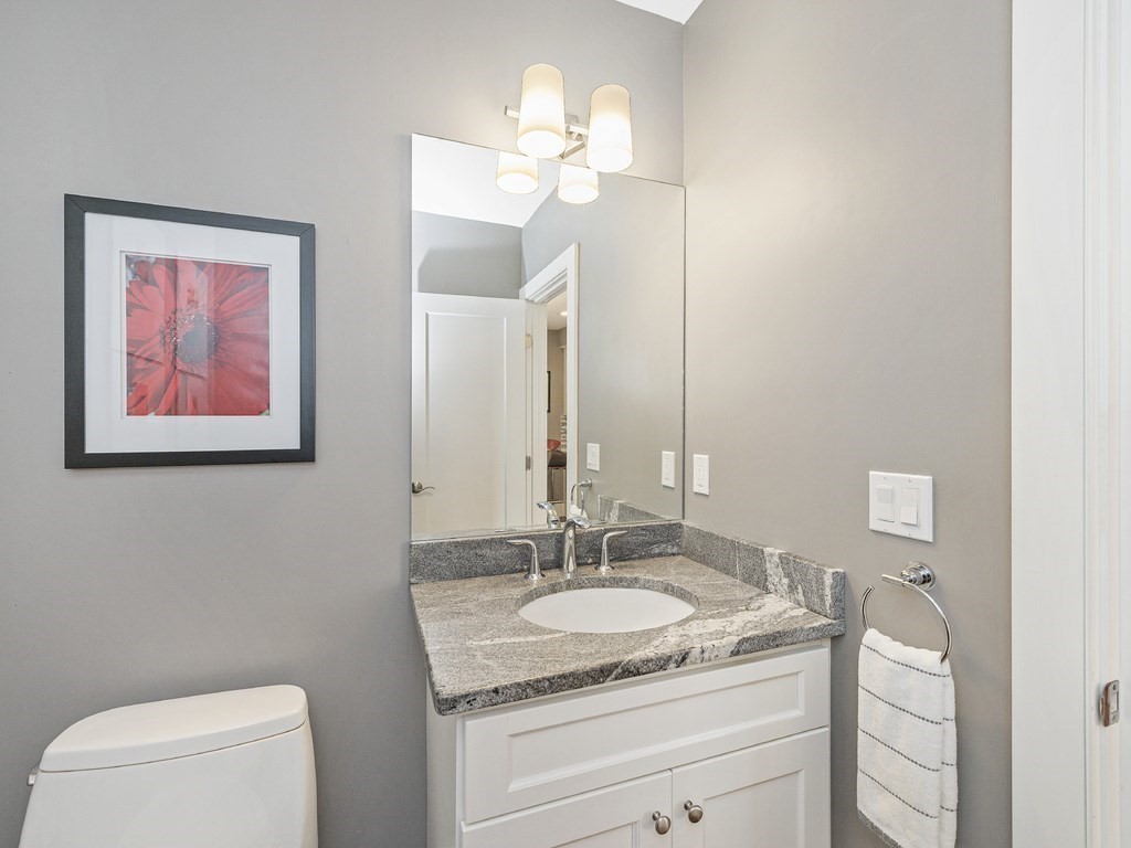 198 California Street, Unit 3 Newton, MA 02458 - Photo 29 of 34 a bathroom with a granite countertop sink a toilet and a mirror