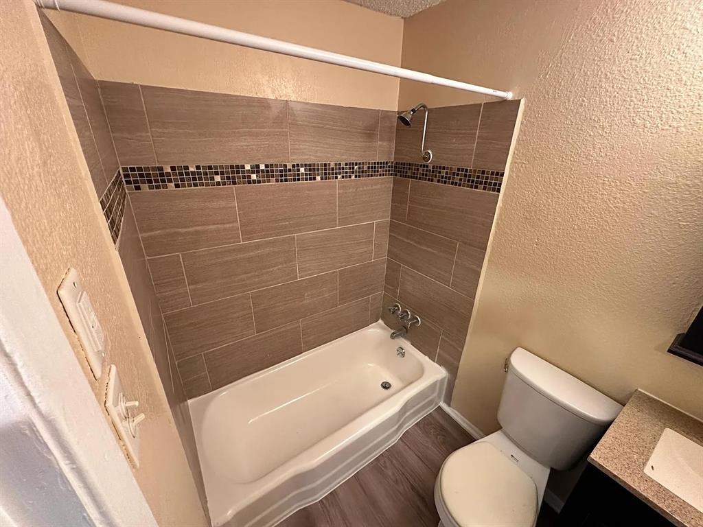 2401 Manor Road, Unit 220 Austin, TX 78722 - Photo 3 of 17 A classic bathtub is surrounded by modern tiling and neutral walls.