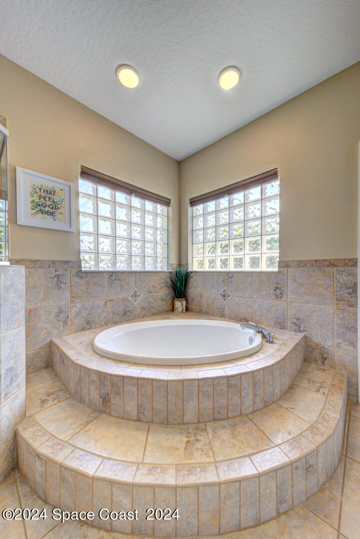 4070 Stoney Point Road Melbourne, FL 32940 - Photo 40 of 75 a bathroom with a bathtub and window