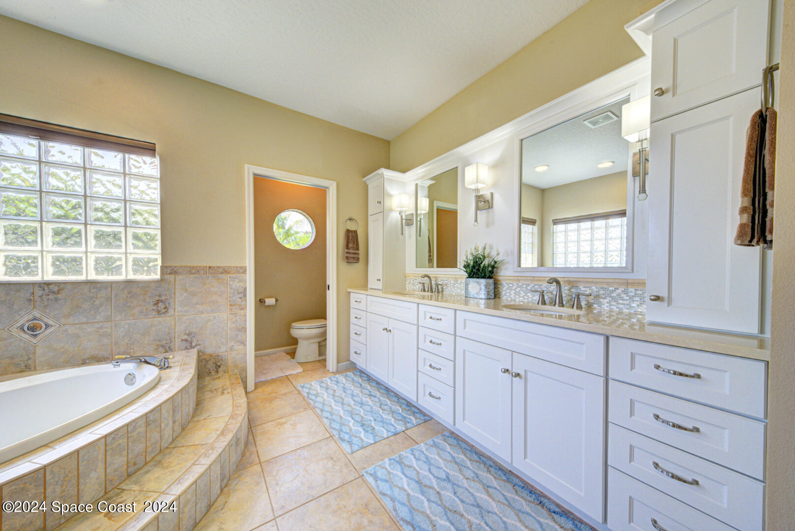 4070 Stoney Point Road Melbourne, FL 32940 - Photo 42 of 75 a spacious bathroom with a granite countertop tub sink and mirror