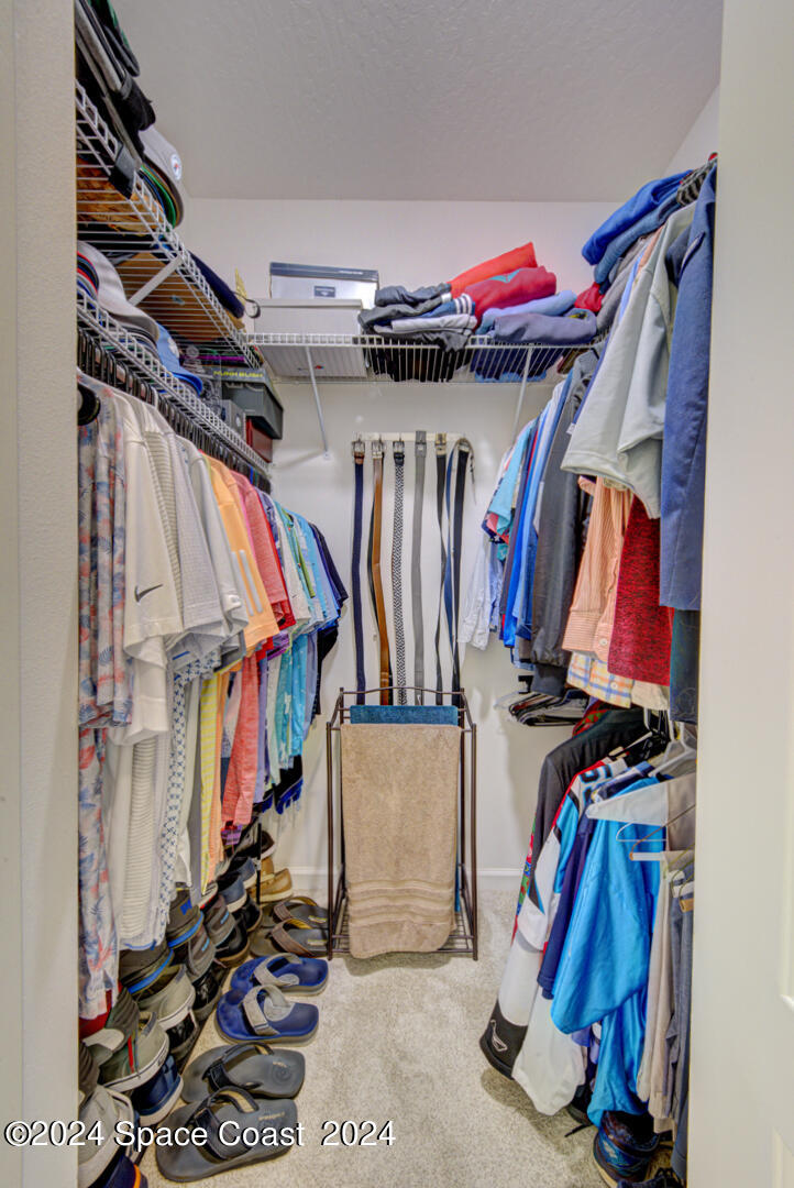 4070 Stoney Point Road Melbourne, FL 32940 - Photo 45 of 75 a view of walk in closet with clothes and shoes