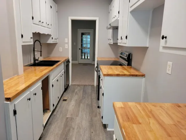 a kitchen with sink a stove and cabinets