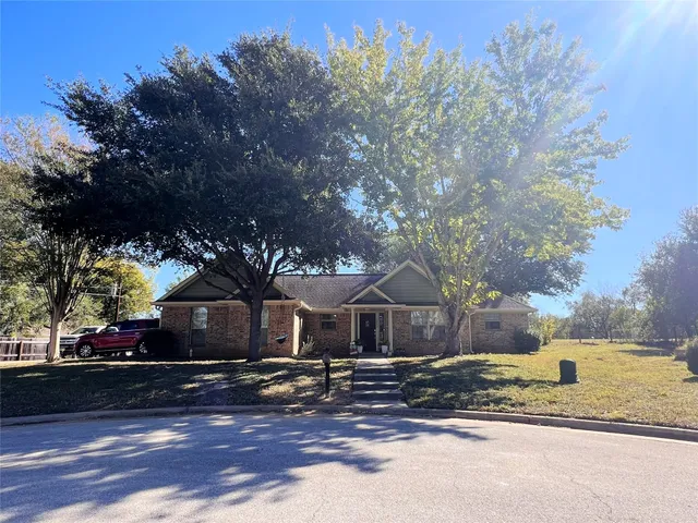 a front view of a house with a yard and trees