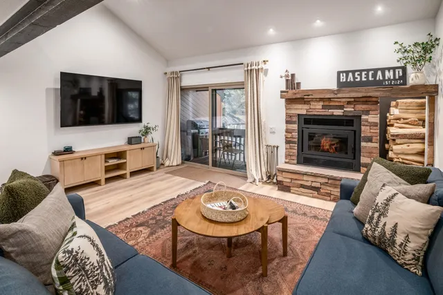 a living room with furniture a flat screen tv and a fireplace