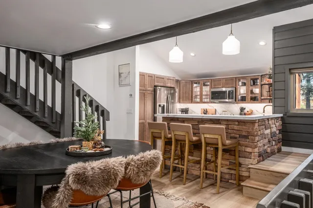 a dining table with chairs and view of kitchen
