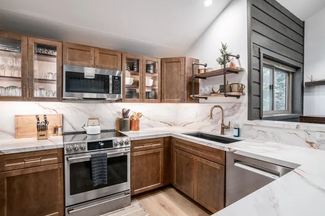 a kitchen with stainless steel appliances granite countertop a sink and stove top oven