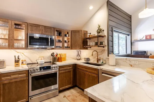 a kitchen with stainless steel appliances granite countertop a sink stove and microwave