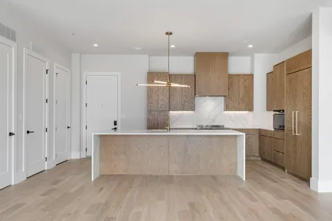 a large kitchen with kitchen island a sink stainless steel appliances and cabinets