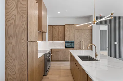 a kitchen with stainless steel appliances kitchen island granite countertop a sink and a refrigerator