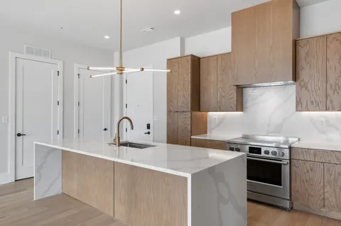 a kitchen with stainless steel appliances a sink stove and refrigerator