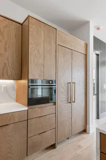 a close view of a refrigerator in kitchen and stainless steel appliances wooden cabinet