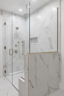 a bathroom with a glass shower door and a shower