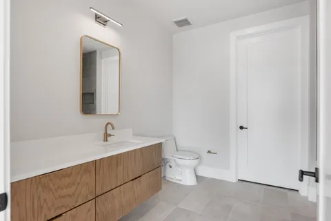 a bathroom with a toilet a sink and mirror