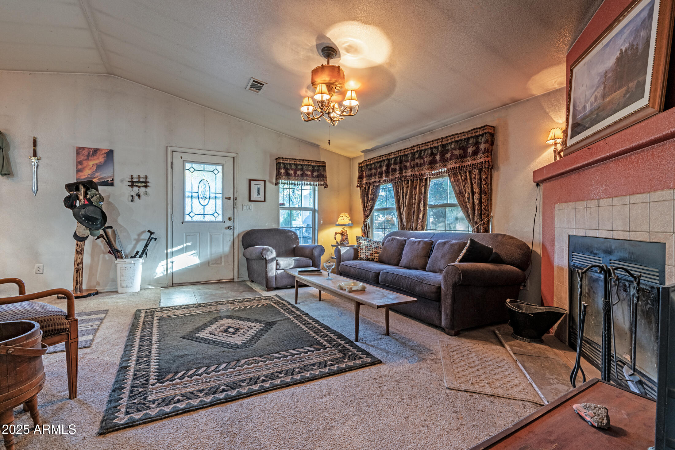 2179 Hackamore Drive Overgaard, AZ 85933 - Photo 3 of 26 a living room with furniture a chandelier and a fireplace
