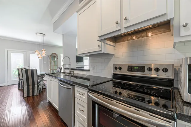 a kitchen with a stove a sink and cabinets