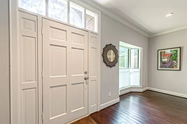 an empty room with wooden floor mirror and windows
