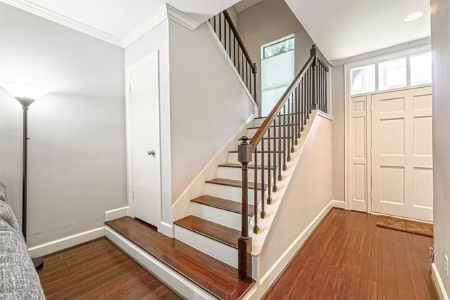 a view of a hallway with wooden floor and staircase