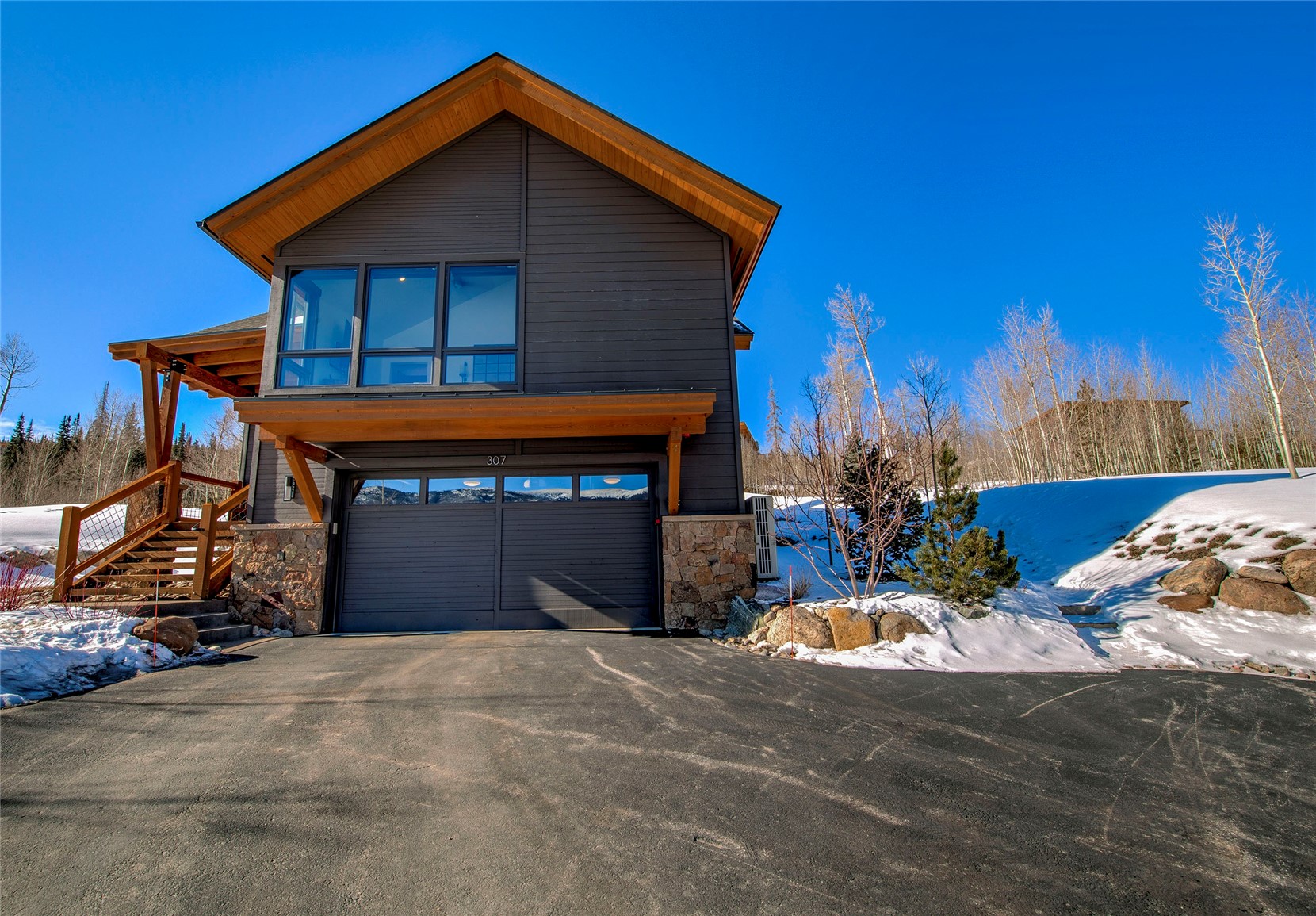 307 Maryland Creek Road Silverthorne, CO 80498 - Photo 37 of 47 View of front facade featuring stone siding, driveway, and a garage
