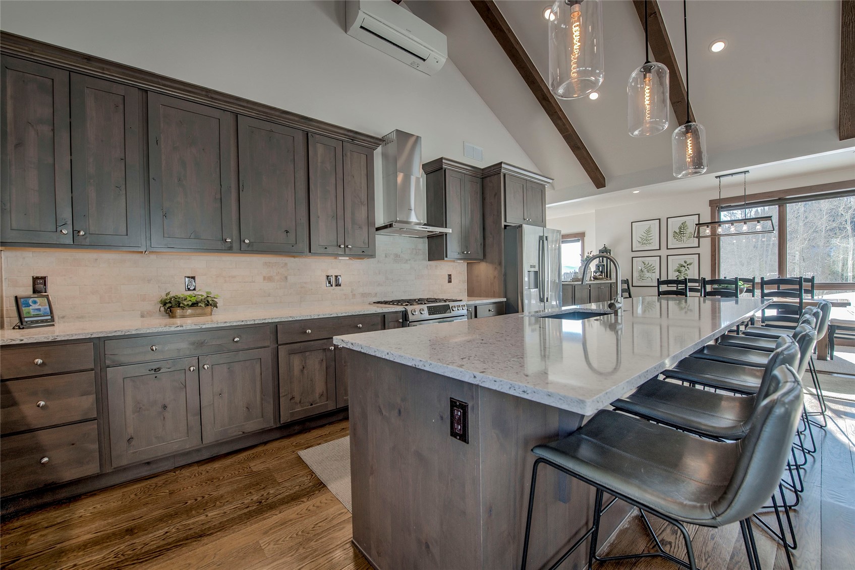307 Maryland Creek Road Silverthorne, CO 80498 - Photo 5 of 47 Kitchen with light stone counters, a kitchen island with sink, and dark wood-style flooring.