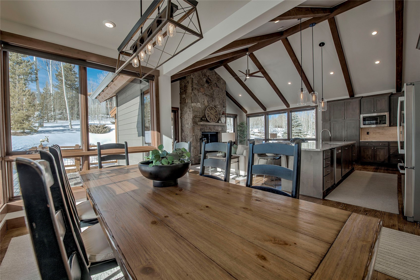 307 Maryland Creek Road Silverthorne, CO 80498 - Photo 9 of 47 Dining area featuring a stone fireplace, high vaulted ceiling, recessed lighting, dark wood-type flooring, and beam ceiling