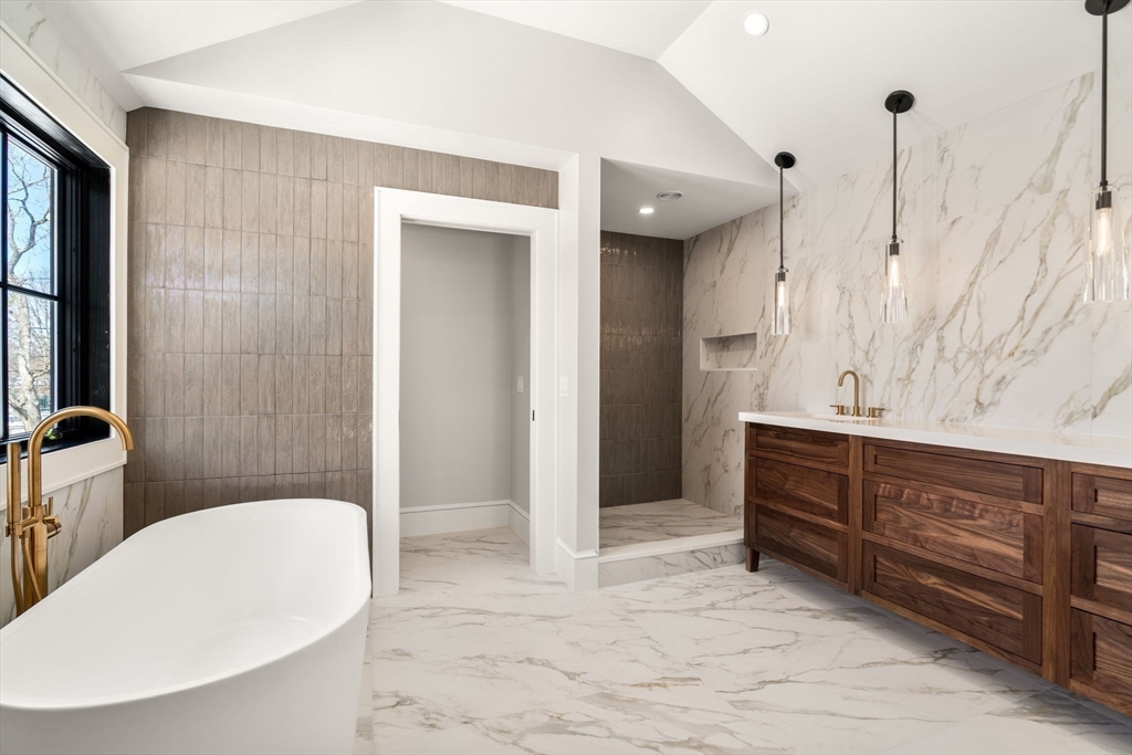 577 Grove Street Newton, MA 02462 - Photo 14 of 29 a bathroom with a tub sink and mirror