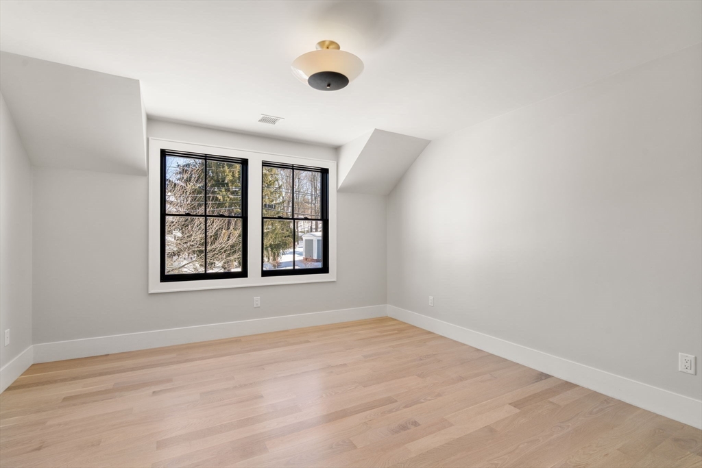 577 Grove Street Newton, MA 02462 - Photo 18 of 29 an empty room with wooden floor and windows