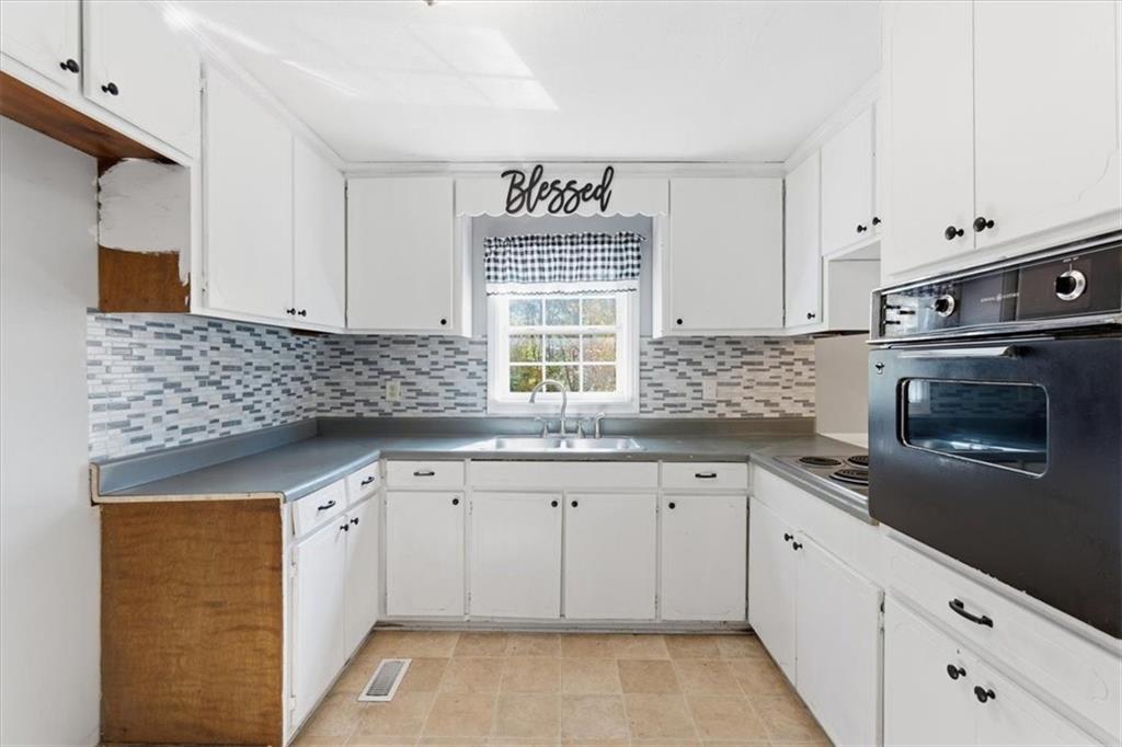 1500 Moores Ferry Road Southwest Plainville, GA 30733 - Photo 23 of 33 a kitchen with granite countertop white cabinets and a sink