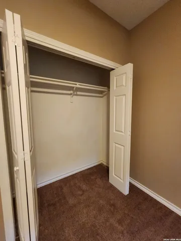 an empty room with a ceiling fan and window