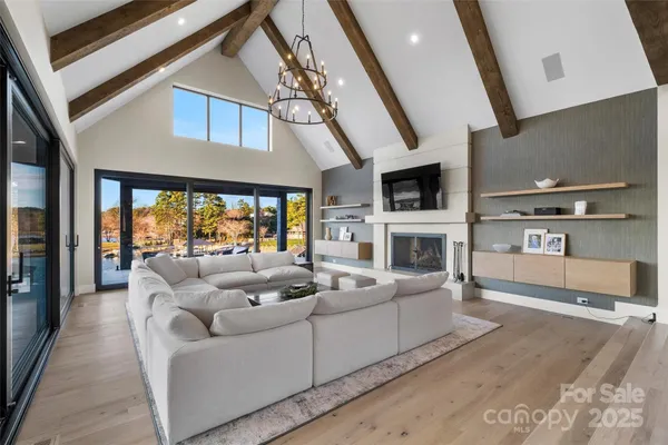 a living room with furniture a large window and a fireplace