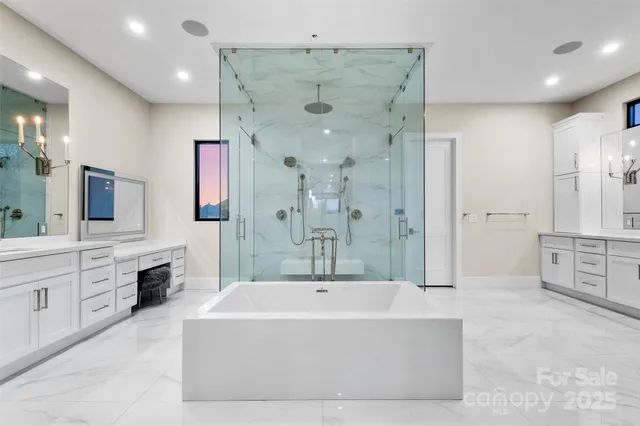 a spacious bathroom with a tub sink shower and mirror