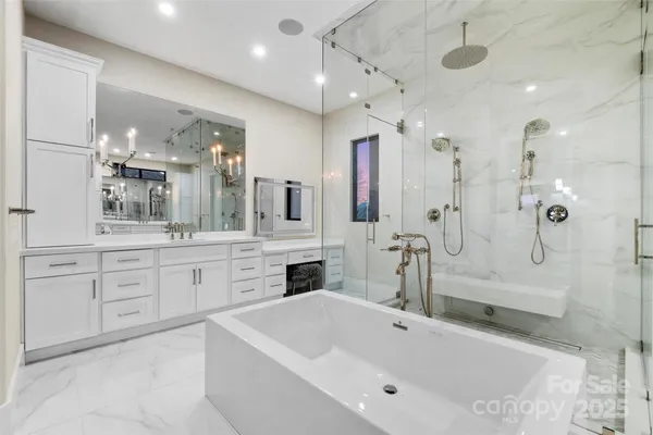a large bathroom with a tub sink a vanity and mirrors