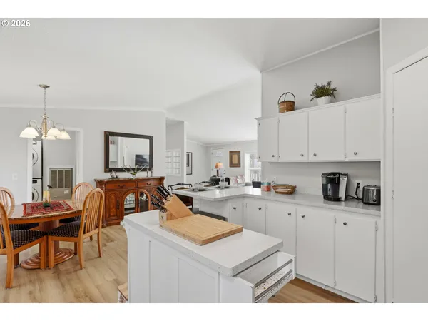 a kitchen that has a sink a stove counter top space and a view of living room