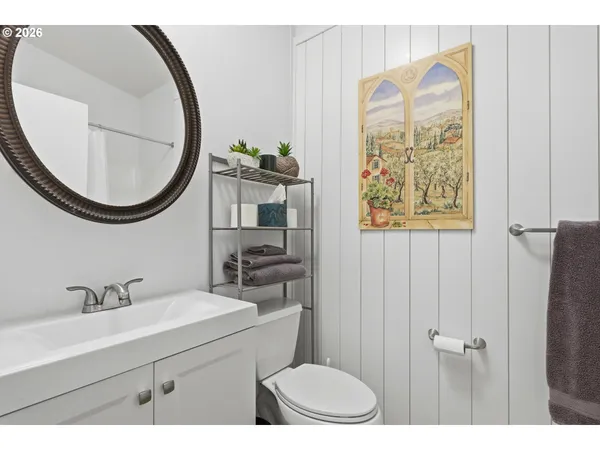 a bathroom with a sink a mirror a toilet and a window