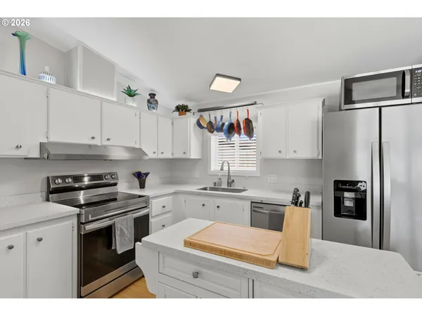 a kitchen with granite countertop white cabinets and stainless steel appliances
