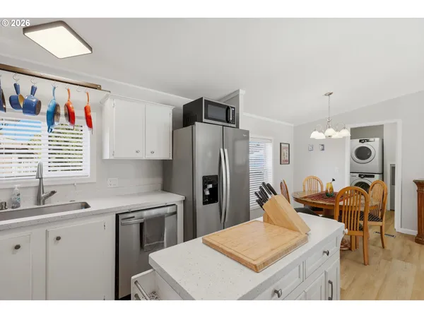 a kitchen with stainless steel appliances kitchen island granite countertop a refrigerator and a sink
