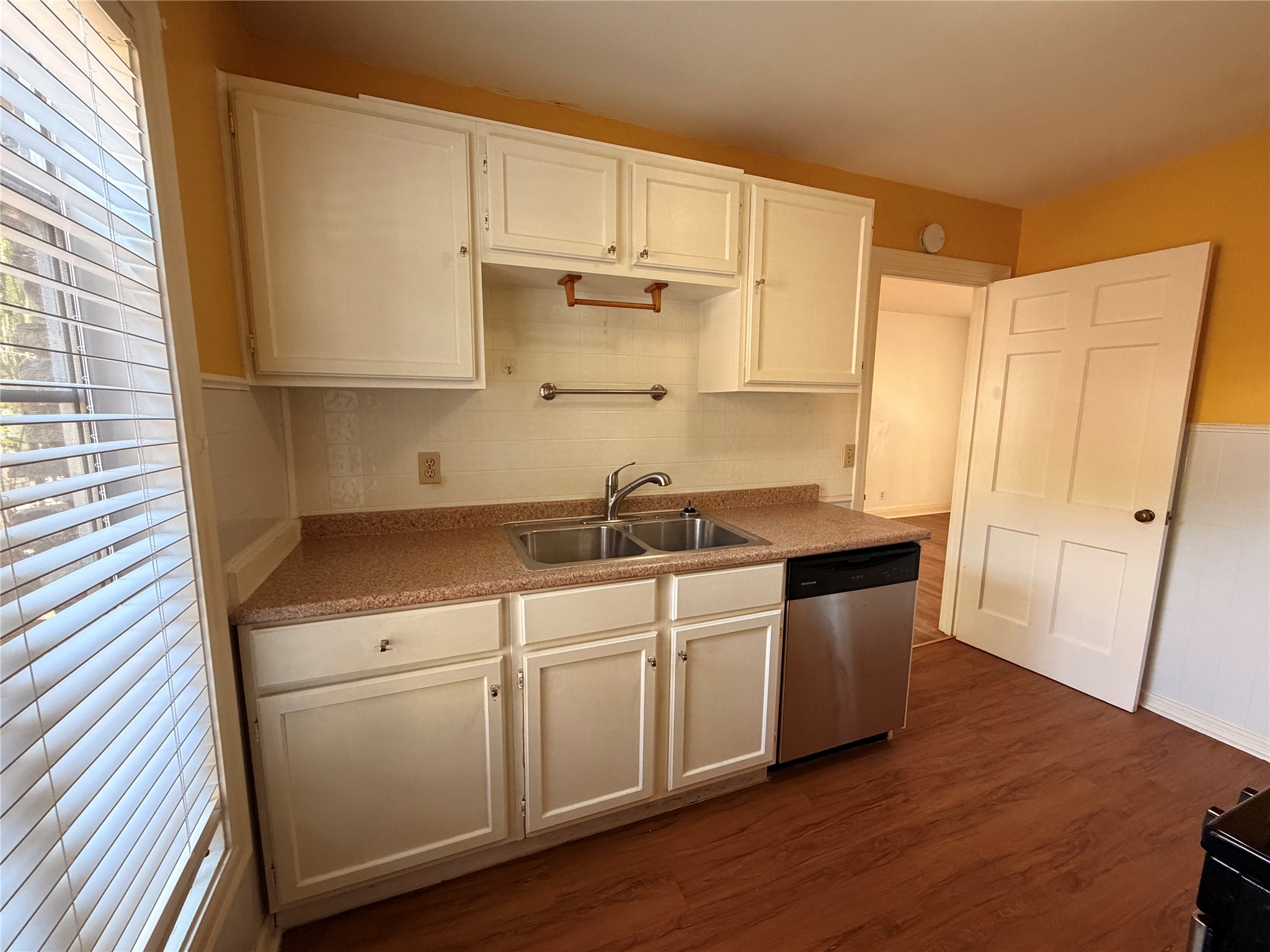 2511 Enfield Road, Unit A Austin, TX 78703 - Photo 7 of 7 Well-lit kitchen with a double basin sink, white cabinetry, and durable flooring.