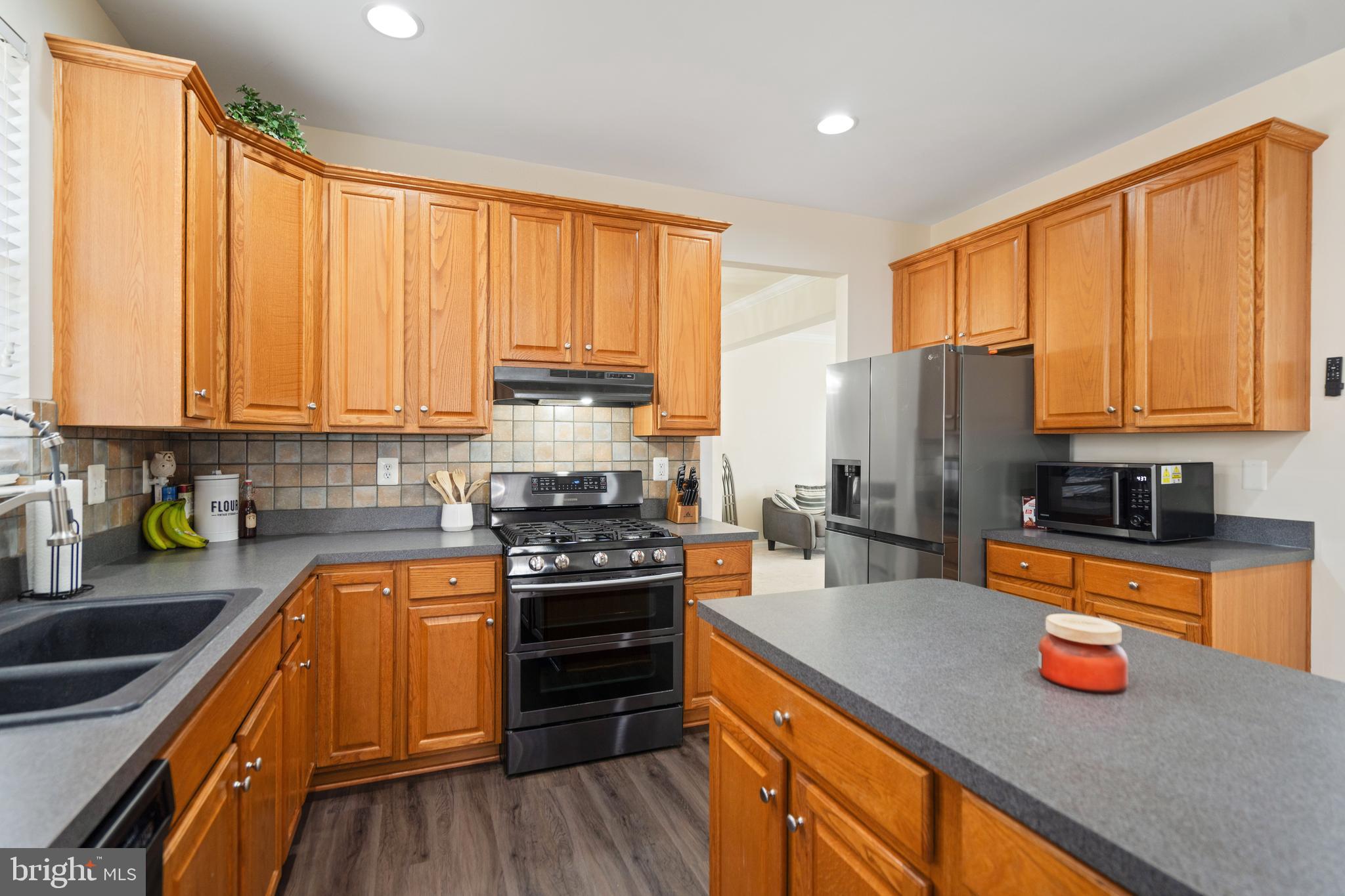 471 Blossom Tree Road Culpeper, VA 22701 - Photo 2 of 26 a kitchen with stainless steel appliances granite countertop a stove top oven a sink dishwasher a refrigerator and cabinets with wooden floor