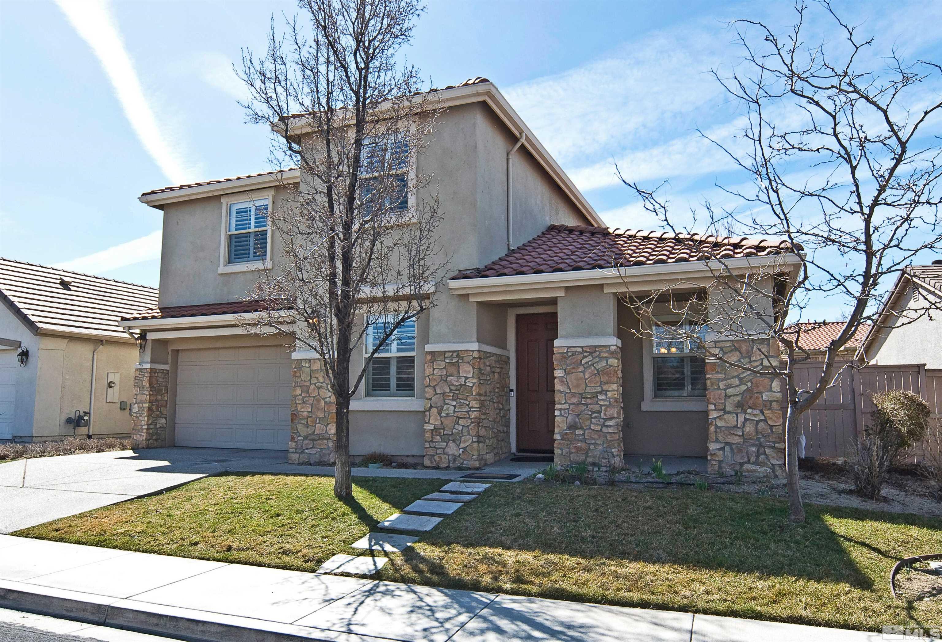 10620 Fire Poppy Circle Reno, NV 89521 - Photo 1 of 25 a view of a white house with a large tree and a yard