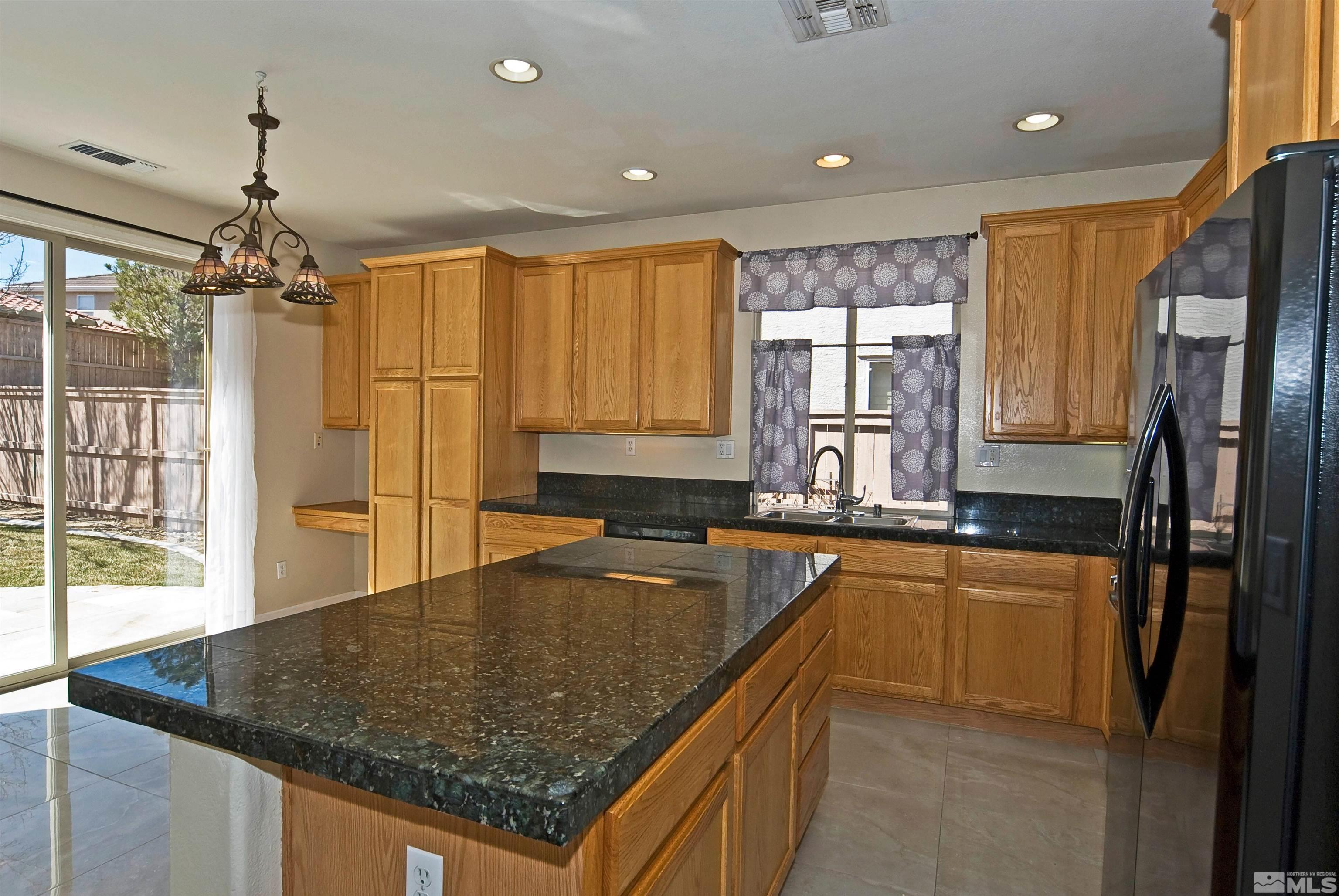 10620 Fire Poppy Circle Reno, NV 89521 - Photo 7 of 25 a kitchen with stainless steel appliances granite countertop a sink a stove and refrigerator