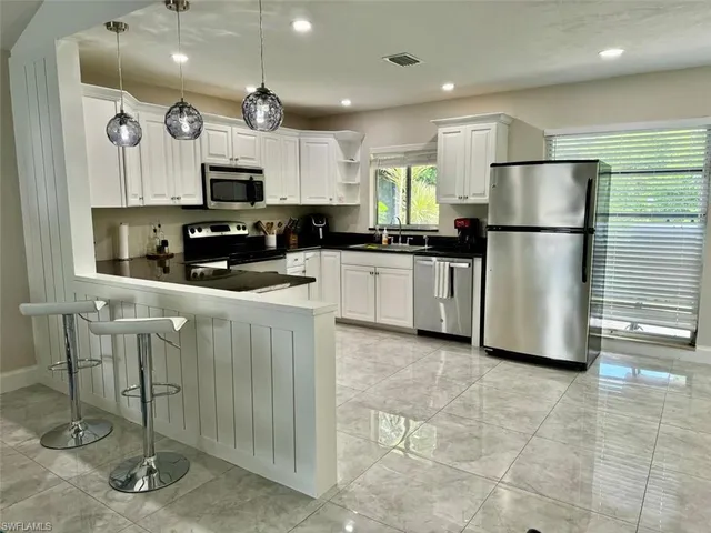 a kitchen with stainless steel appliances granite countertop a refrigerator and a stove top oven