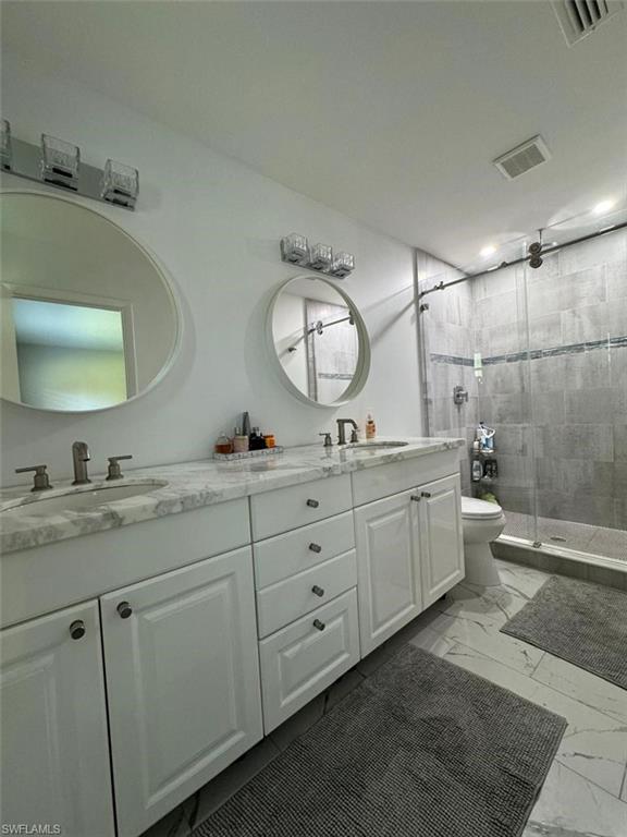 857 Palm View Drive, Unit 32 Naples, FL 34110 - Photo 4 of 9 a spacious bathroom with a double vanity sink mirror and toilet