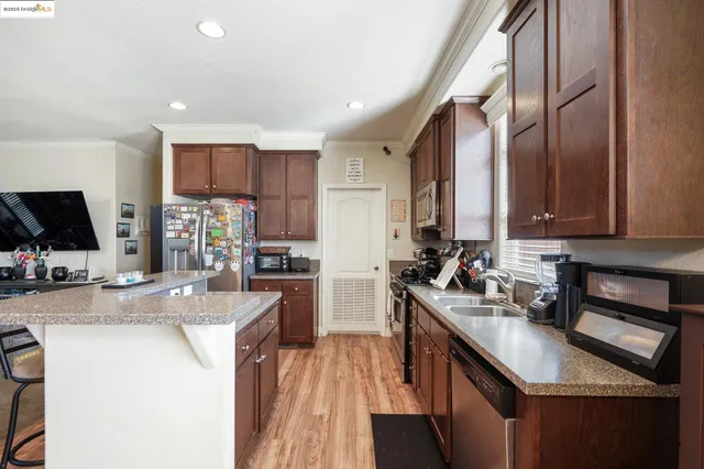 a kitchen with stainless steel appliances granite countertop wooden cabinets a stove top oven a sink and dishwasher
