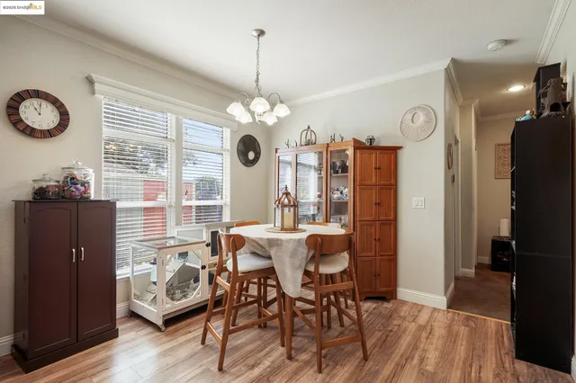 a view of a dining room with furniture a chandelier and wooden floor